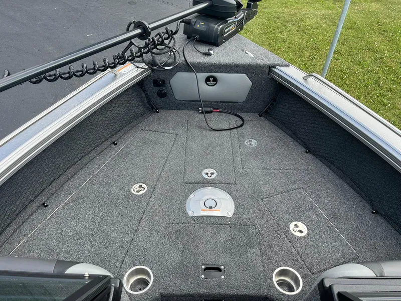 Slide: The Image of 2025 Lund 1975 Tyee boat interior with carpeted deck and fishing rod holders. - 19