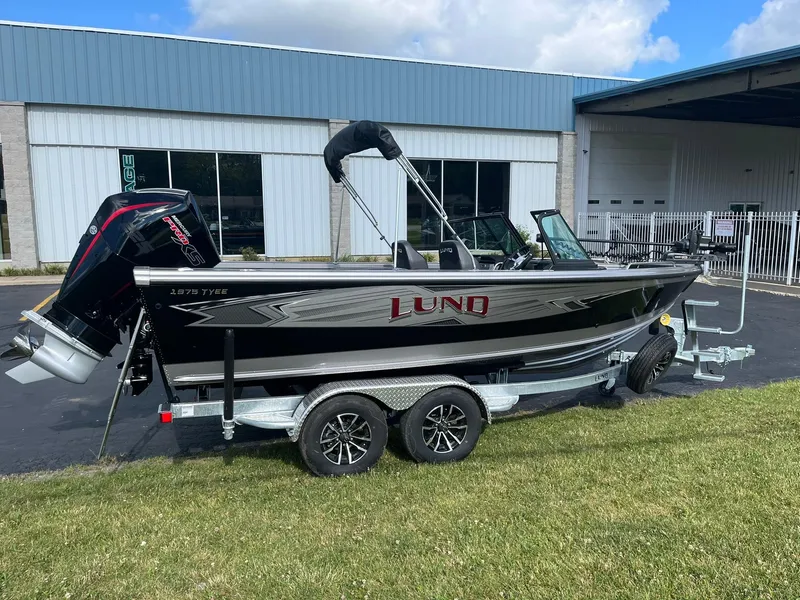 Slide: The Image of 2025 Lund 1975 Tyee boat on a trailer, parked outside a building. - 28