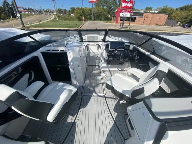 Slide: The Image of 2024 Yamaha Boats 252SD interior with modern seating and dashboard, parked near a Wendy's. - 12