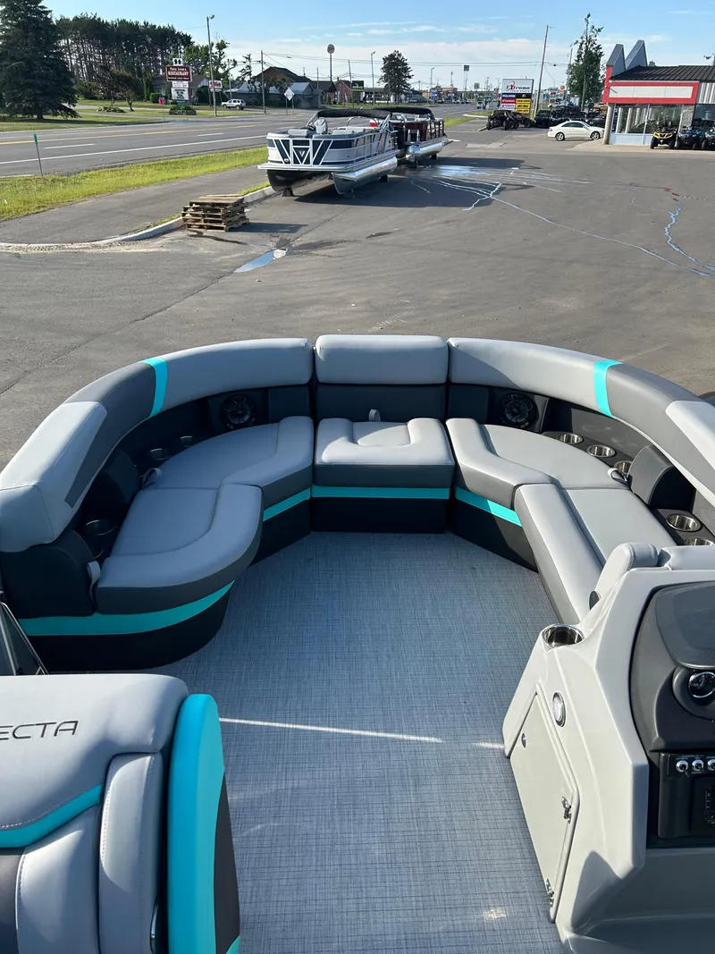 Slide: The Image of 2025 Trifecta 20CCS pontoon boat with spacious seating, parked in a dealership lot. - 2