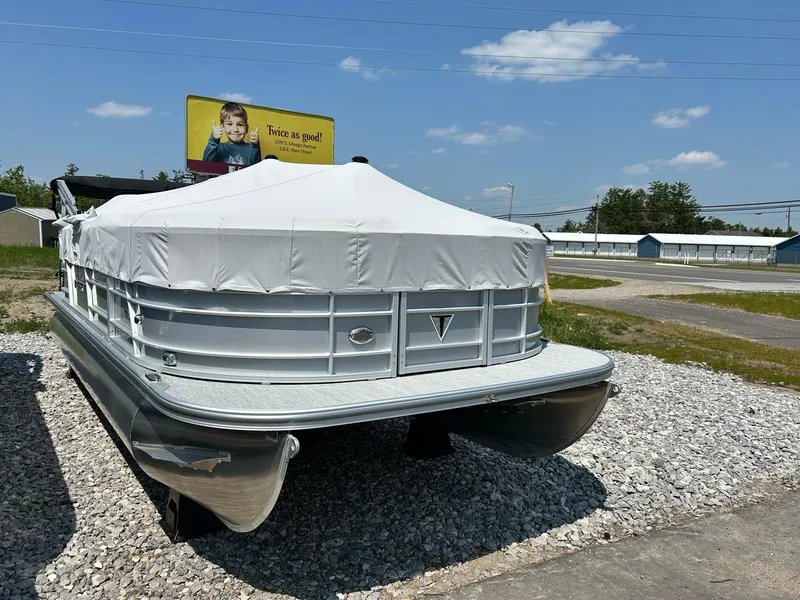 Slide: The Image of 2025 Trifecta 20CCS pontoon boat covered, parked on gravel under a clear blue sky. - 9