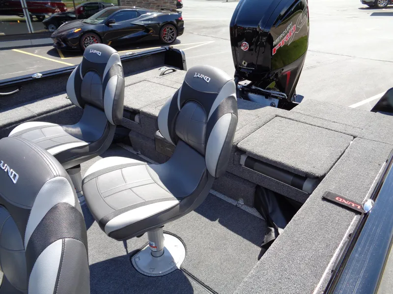 Slide: The Image of 2024 Lund 1875 Impact XS boat interior with seating and motor. - 12