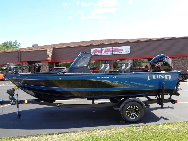 Slide: The Image of 2024 Lund 1875 Impact XS boat on trailer, parked outside a building. - 8