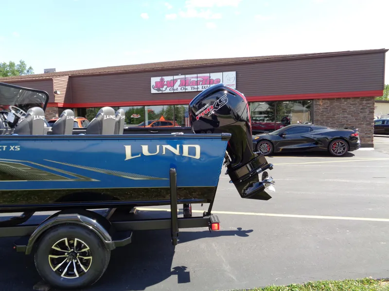 Slide: The Image of 2024 Lund 1875 Impact XS boat on trailer, parked outside a dealership. - 9