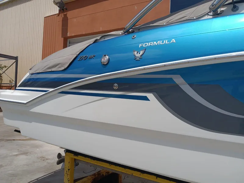 Slide: The Image of 2019 Formula 270 Bowrider boat with blue and white exterior on a trailer. - 39