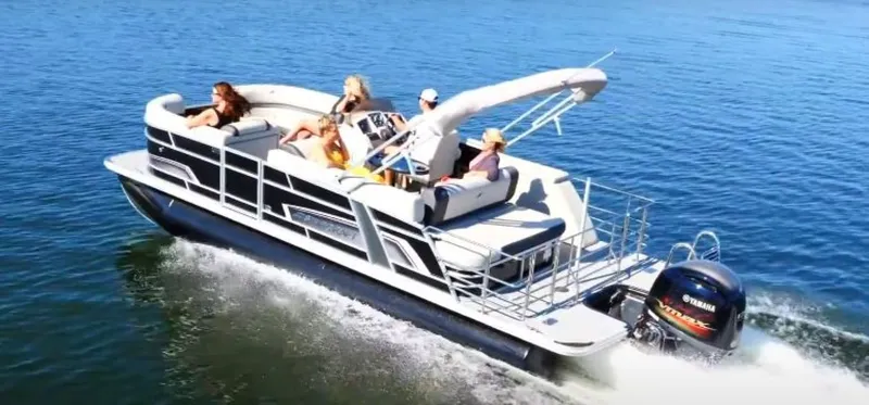 Slide: The Image of 2025 Starcraft EXS 3 Q pontoon boat cruising on a sunny lake with passengers. - 3