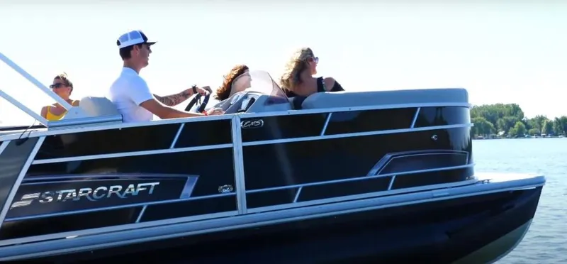Slide: The Image of 2025 Starcraft EXS 3 Q pontoon boat cruising on a sunny lake with passengers. - 5