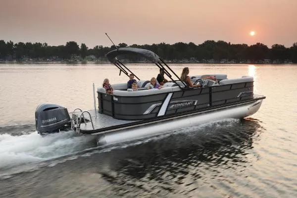 Slide: The Image of 2025 Starcraft EXS 3 Q pontoon boat cruising on a lake at sunset. - 7