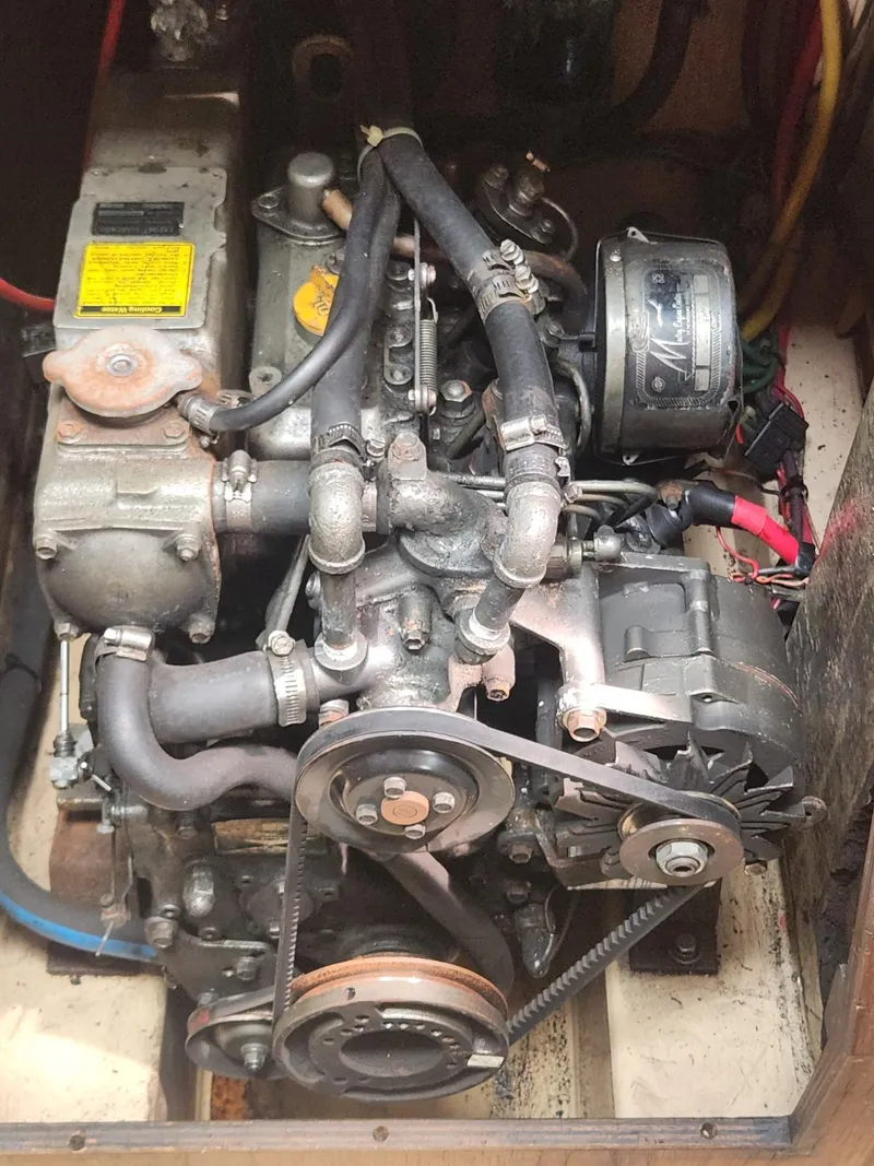 Slide: The Image of Engine of a 1989 Island Packet 35 sailboat, showcasing mechanical components and belts. - 100