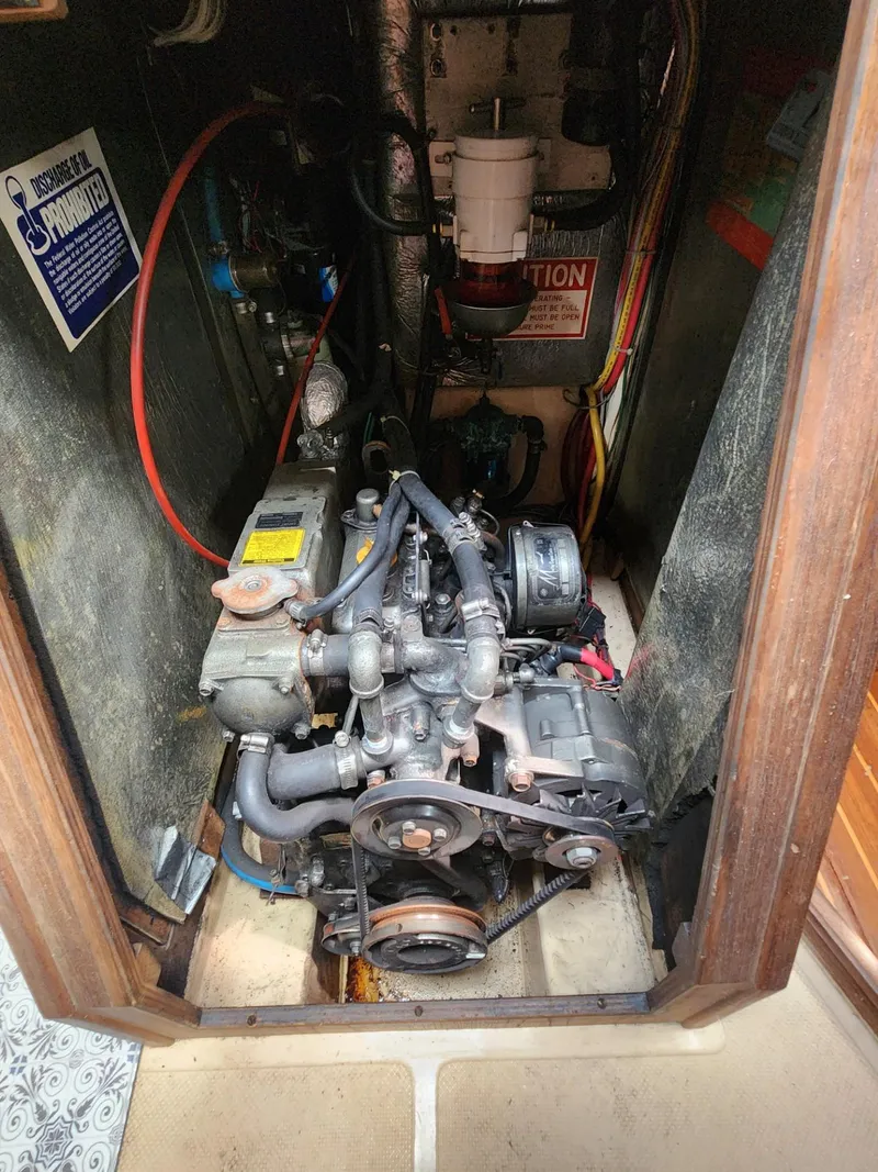 Slide: The Image of Engine compartment of a 1989 Island Packet 35 sailboat, showcasing mechanical components. - 101