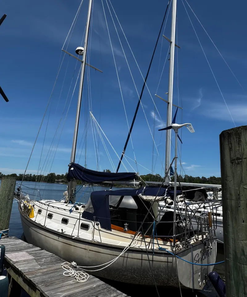 Slide: The Image of 1989 Island Packet 35 sailboat cockpit with cushioned seating and nautical equipment. - 11