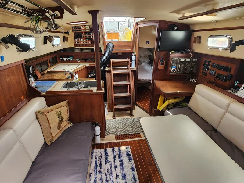 Slide: The Image of 1989 Island Packet 35 sailboat cockpit with ropes and seating at a marina. - 20