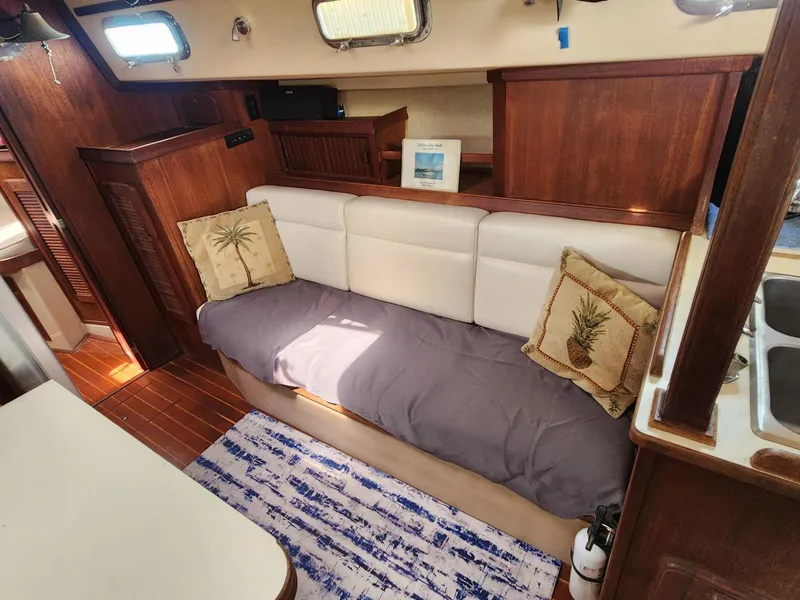 Slide: The Image of 1989 Island Packet 35 sailboat cockpit with seating, marina view, and nautical equipment. - 22