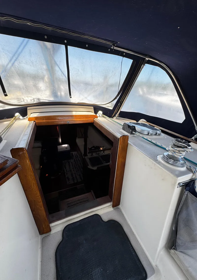 Slide: The Image of 1989 Island Packet 35 sailboat with blue canvas cover at marina. - 50