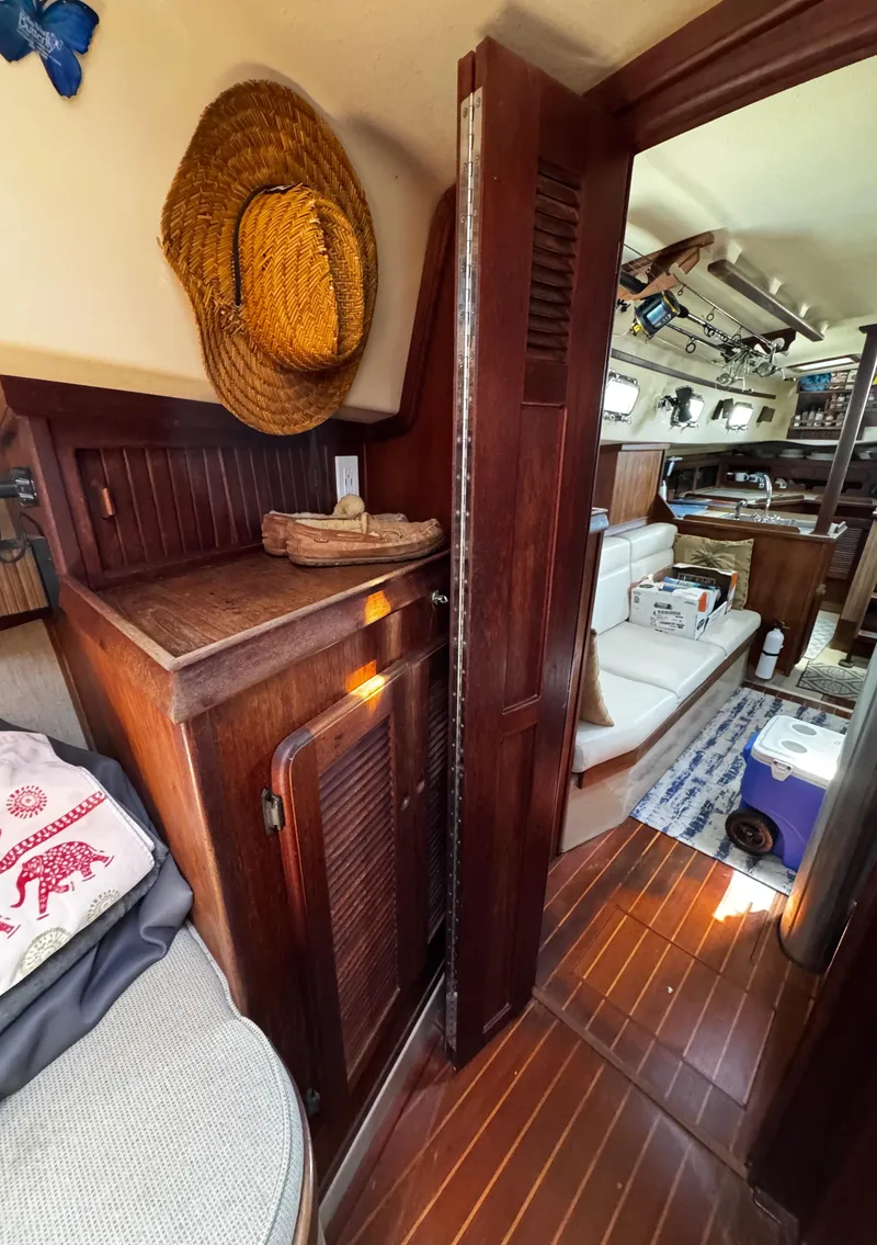 Slide: The Image of Cozy cabin interior of 1989 Island Packet 35 sailboat with cushions and floral bedding. - 71