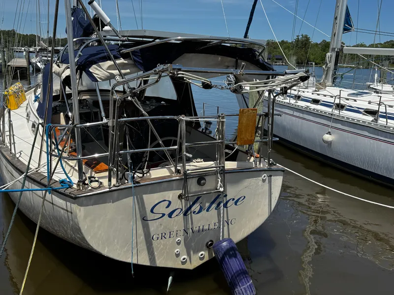 Slide: The Image of 1989 Island Packet 35 sailboat docked at marina with solar panels and wind turbine. - 8
