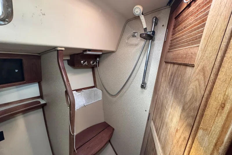 Slide: The Image of 1989 Island Packet 35 sailboat interior shower with wooden accents and compact design. - 80