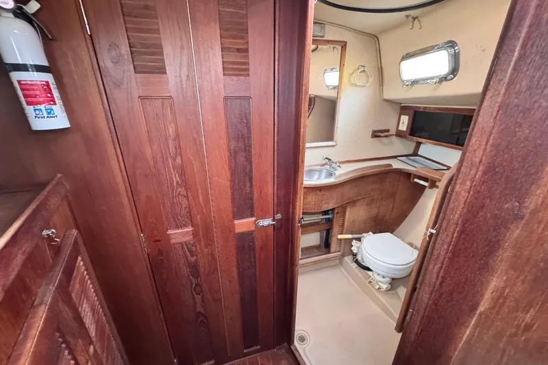 Slide: The Image of 1989 Island Packet 35 yacht bathroom with wooden cabinetry and compact design. - 84