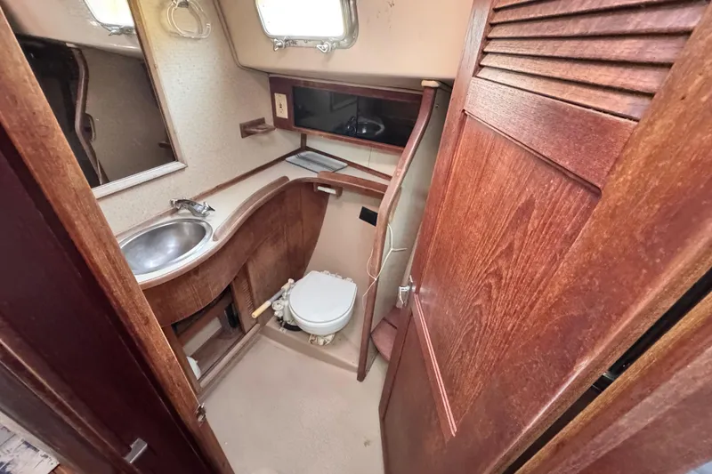 Slide: The Image of 1989 Island Packet 35 sailboat bathroom with wooden cabinetry and compact design. - 88