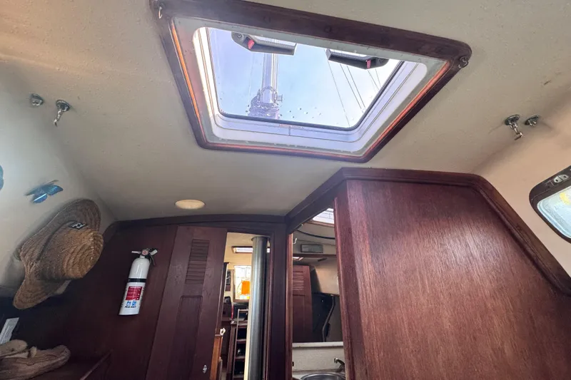 Slide: The Image of Interior view of 1989 Island Packet 35 sailboat with wooden finishes and skylight. - 91