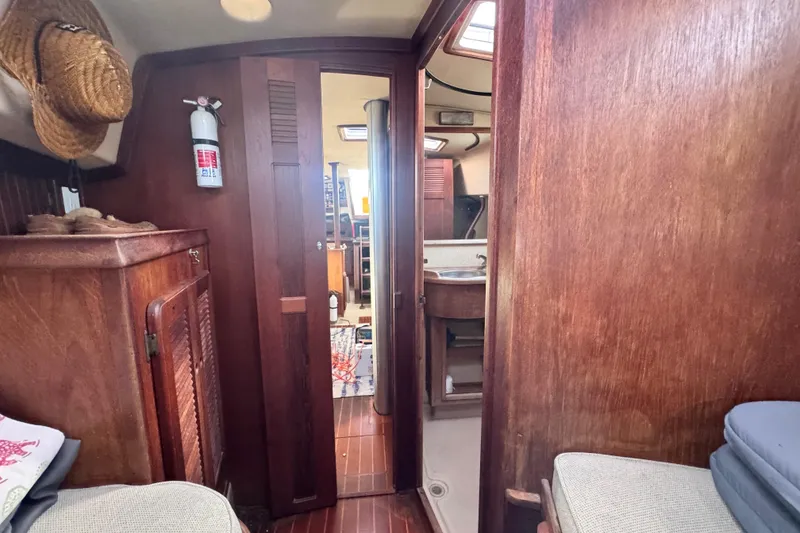 Slide: The Image of Interior of 1989 Island Packet 35 sailboat with wooden cabinetry and cozy seating. - 92