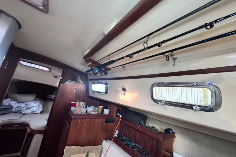Slide: The Image of Interior of 1989 Island Packet 35 sailboat with fishing rods and cozy cabin. - 93
