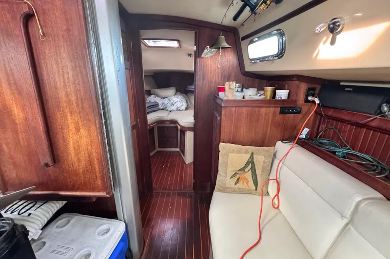 Slide: The Image of Interior of 1989 Island Packet 35 sailboat with wooden finishes and cozy seating area. - 94