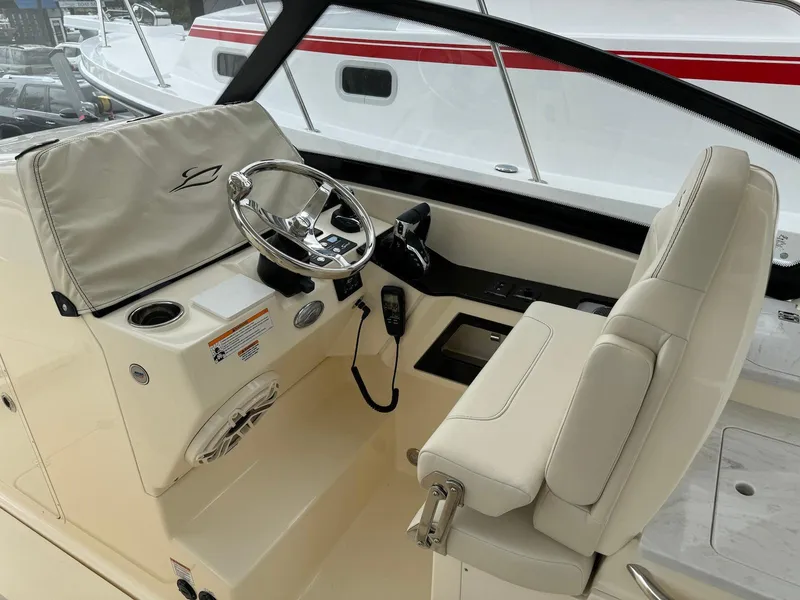Slide: The Image of 2025 Scout 277 Dorado boat helm with steering wheel and controls. - 12