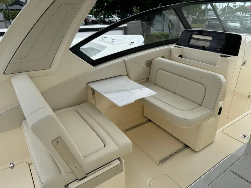 Slide: The Image of 2025 Scout 277 Dorado boat interior with beige seating and a small table. - 14