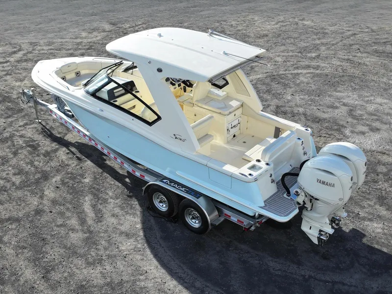 Slide: The Image of 2025 Scout 277 Dorado boat on trailer with Yamaha engine, parked on gravel. - 3
