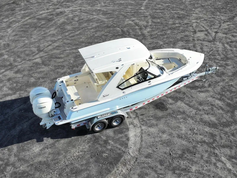 Slide: The Image of 2025 Scout 277 Dorado boat on trailer, aerial view, parked on gravel surface. - 7