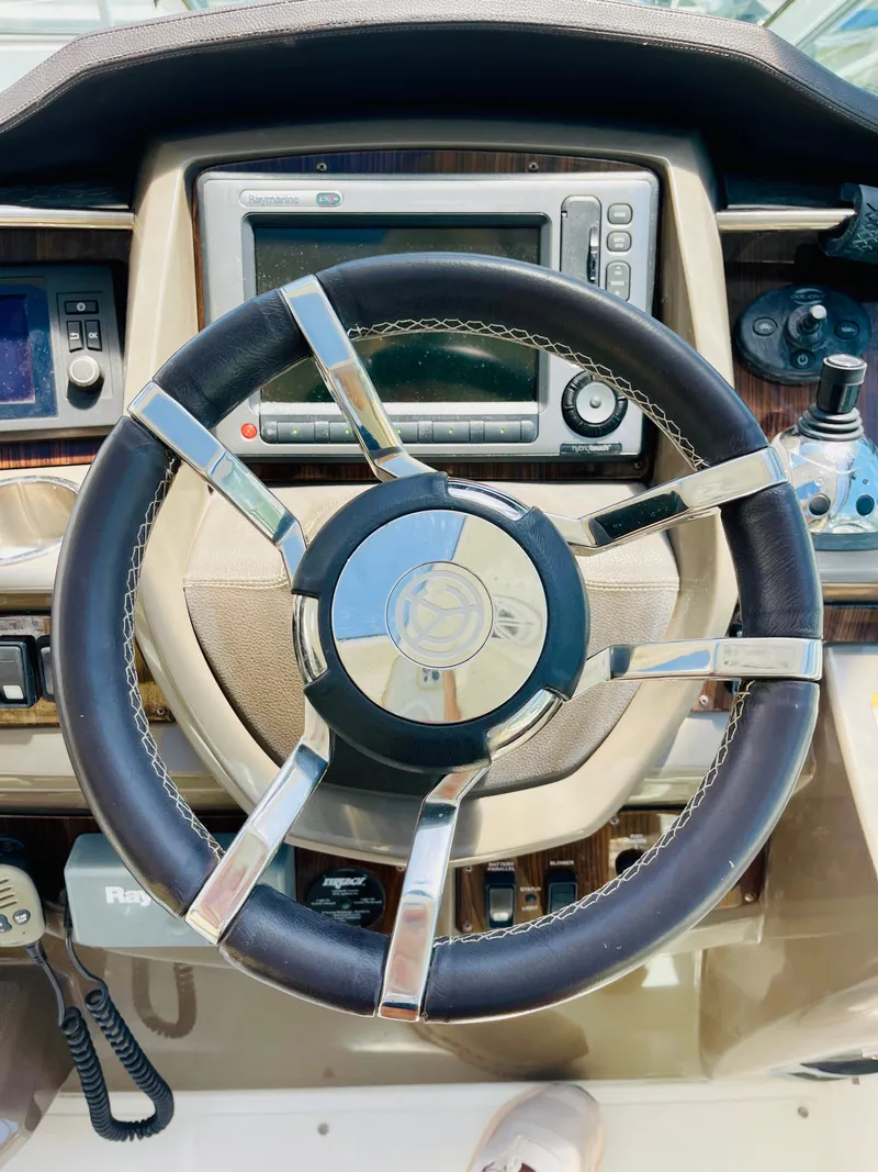 Slide: The Image of Steering wheel and dashboard of a 2012 Cruisers 350 Express boat. - 15