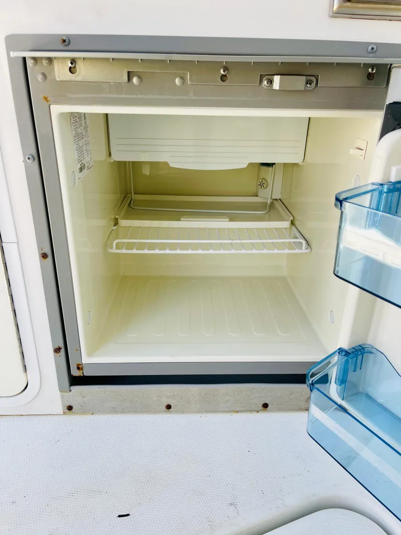 Slide: The Image of 2012 Cruisers 350 Express boat refrigerator, open and empty. - 19