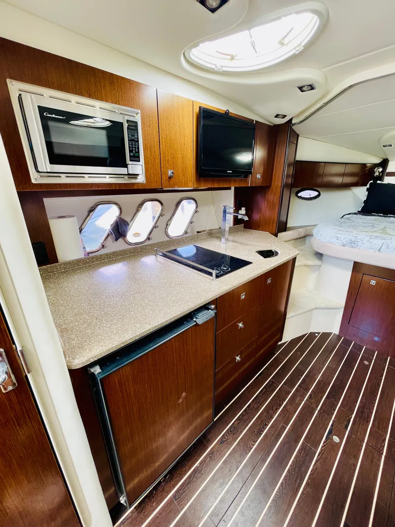 Slide: The Image of 2012 Cruisers 350 Express yacht interior with kitchenette and sleeping area. - 24