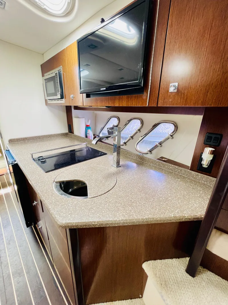 Slide: The Image of 2012 Cruisers 350 Express yacht kitchen with modern appliances and sleek design. - 26