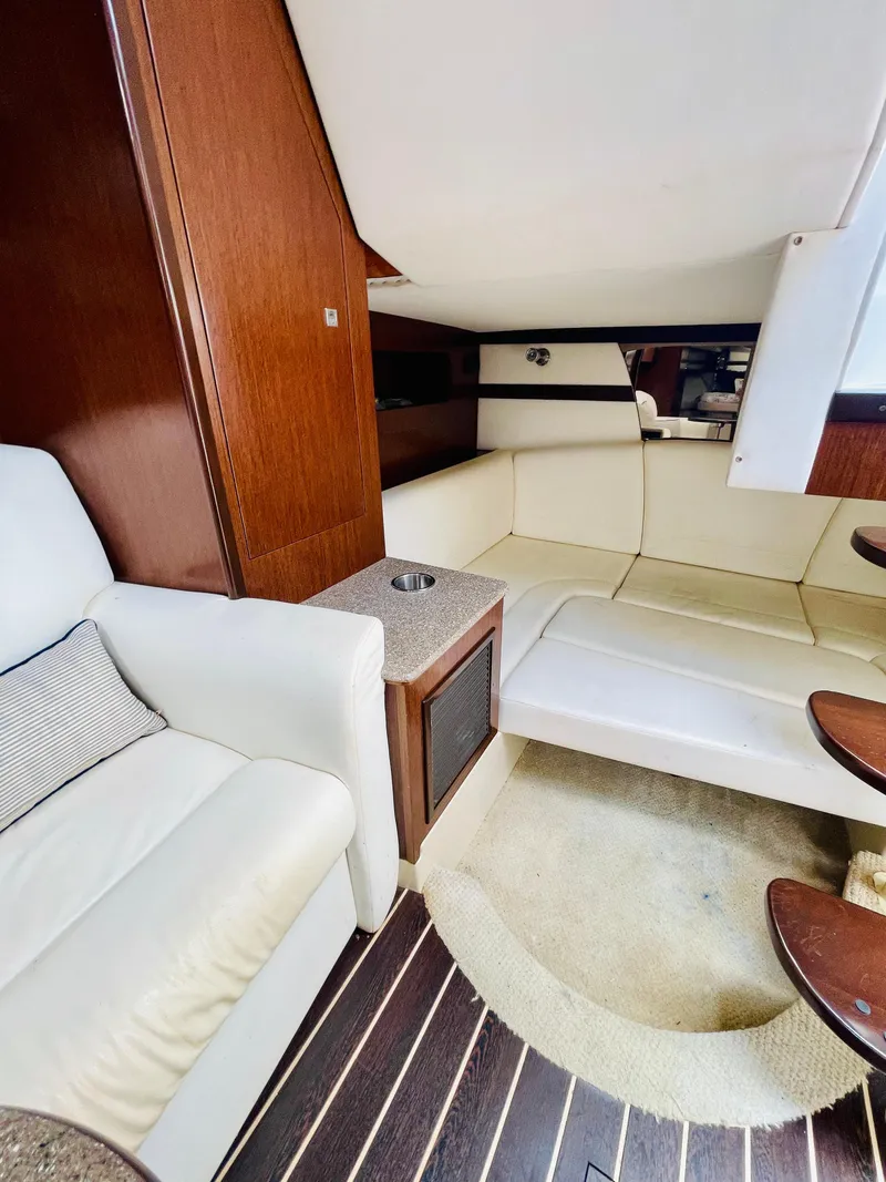 Slide: The Image of Interior of 2012 Cruisers 350 Express yacht with white leather seating and wooden accents. - 28