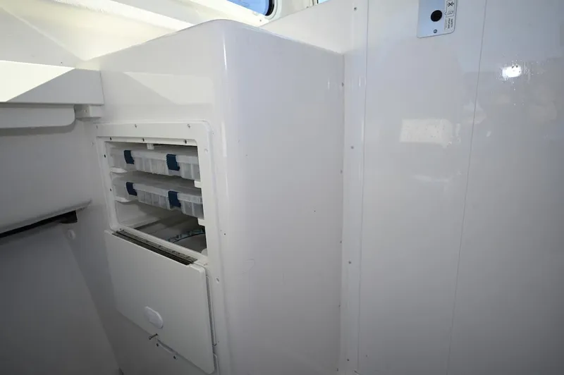 Slide: The Image of 2025 Steiger Craft 255 Miami interior storage compartment with organized tackle boxes. - 10