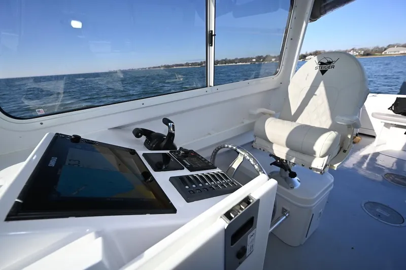 Slide: The Image of 2025 Steiger Craft 255 Miami boat interior with navigation controls and seating. - 13