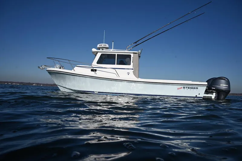 Slide: The Image of 2025 Steiger Craft 255 Miami boat on calm water under clear blue sky. - 3