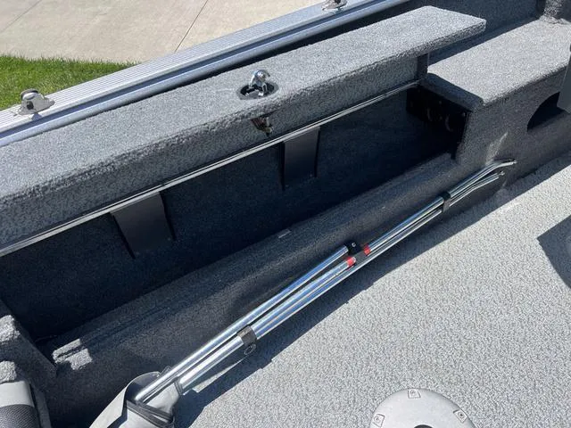 Slide: The Image of 2017 Lund Impact XS 1850 boat interior storage compartment with fishing rod holder. - 12