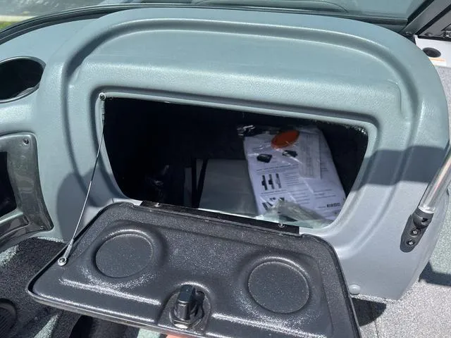 Slide: The Image of 2017 Lund Impact XS 1850 boat glove compartment with open lid and documents inside. - 14