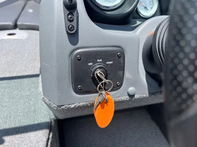 Slide: The Image of Ignition switch of a 2017 Lund Impact XS 1850 boat with key and orange keychain. - 21