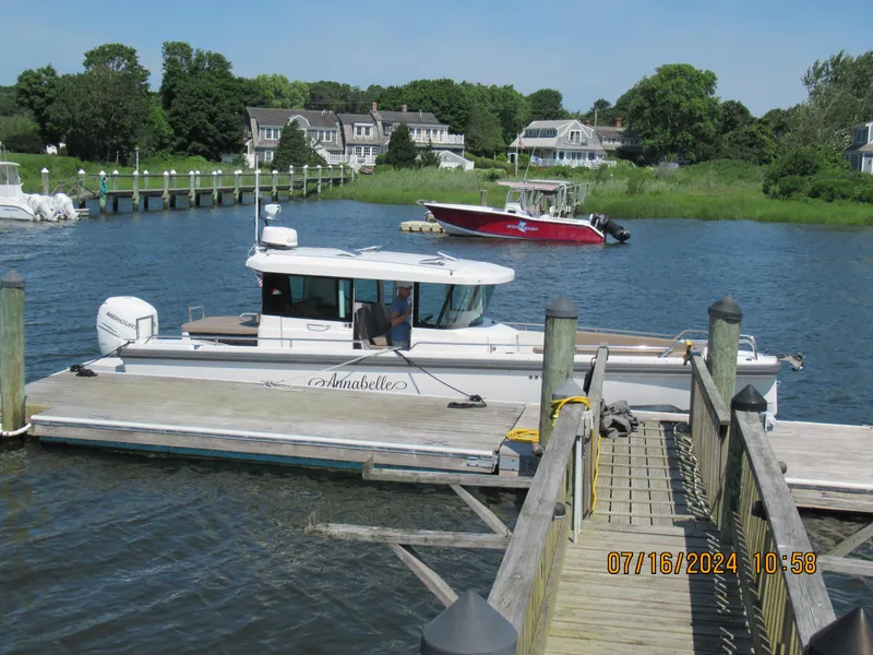 Slide: The Image of Axopar Mark II 2018 boat docked at a marina with scenic background. - 13