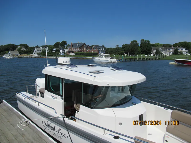 Slide: The Image of Axopar Mark II 2018 boat docked by a scenic waterfront with houses in the background. - 17
