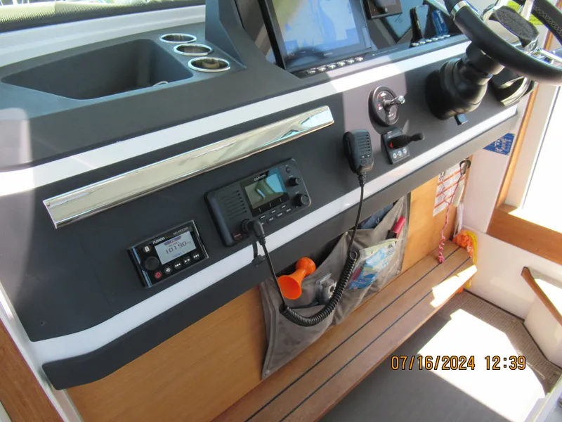 Slide: The Image of 2018 Axopar Mark II boat dashboard with navigation equipment and storage compartments. - 21
