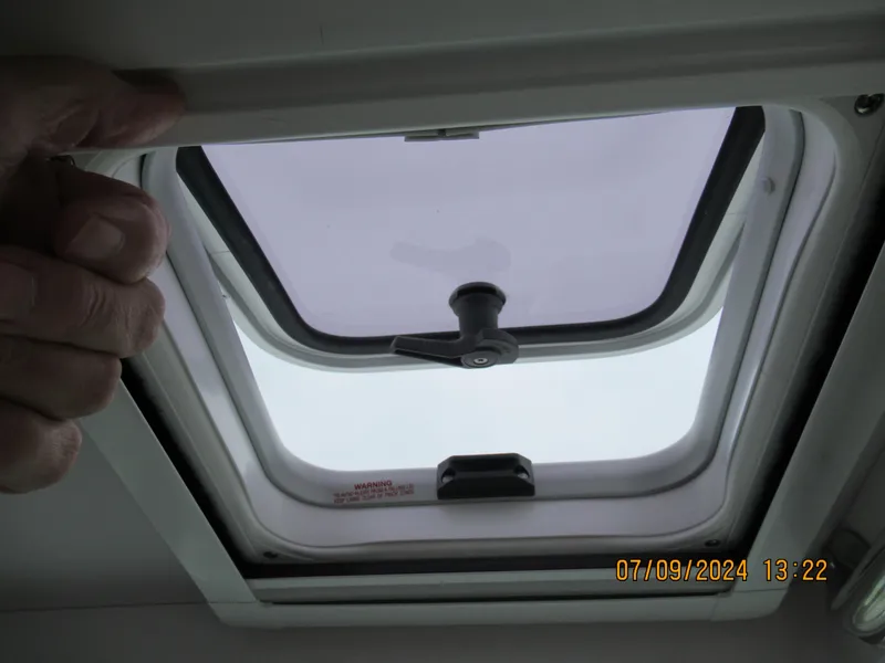 Slide: The Image of Axopar Mark II 2018 boat hatch window, partially open, with hand holding the frame. - 23