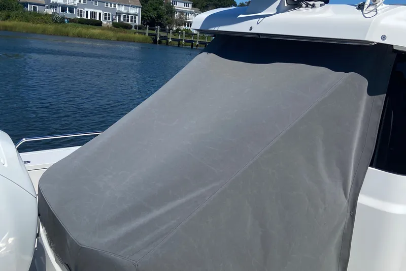 Slide: The Image of Axopar Mark II 2018 boat with a covered windshield, docked near waterfront homes. - 4