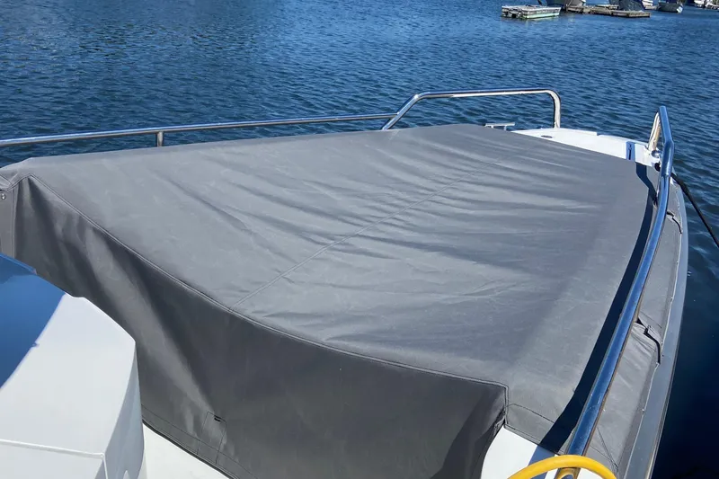 Slide: The Image of Axopar Mark II 2018 boat with covered deck, docked on calm water. - 9