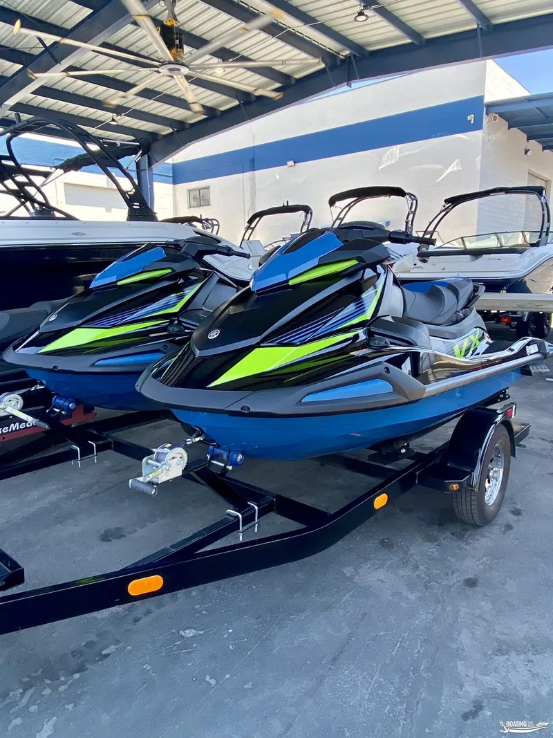 Slide: The Image of 2024 Yamaha WaveRunner VX Deluxe jet skis on a trailer in a covered area. - 2