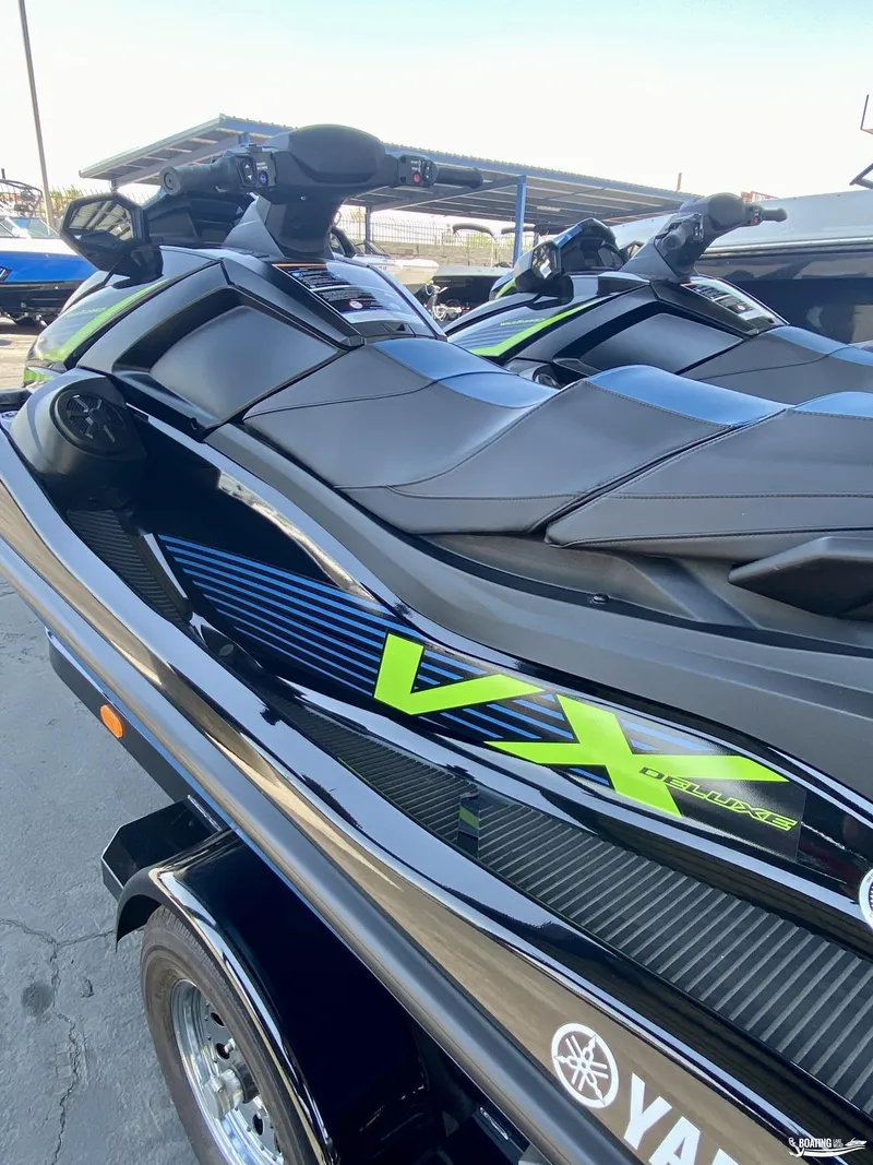 Slide: The Image of 2024 Yamaha WaveRunner VX Deluxe jet ski in black and green, parked on a trailer. - 4